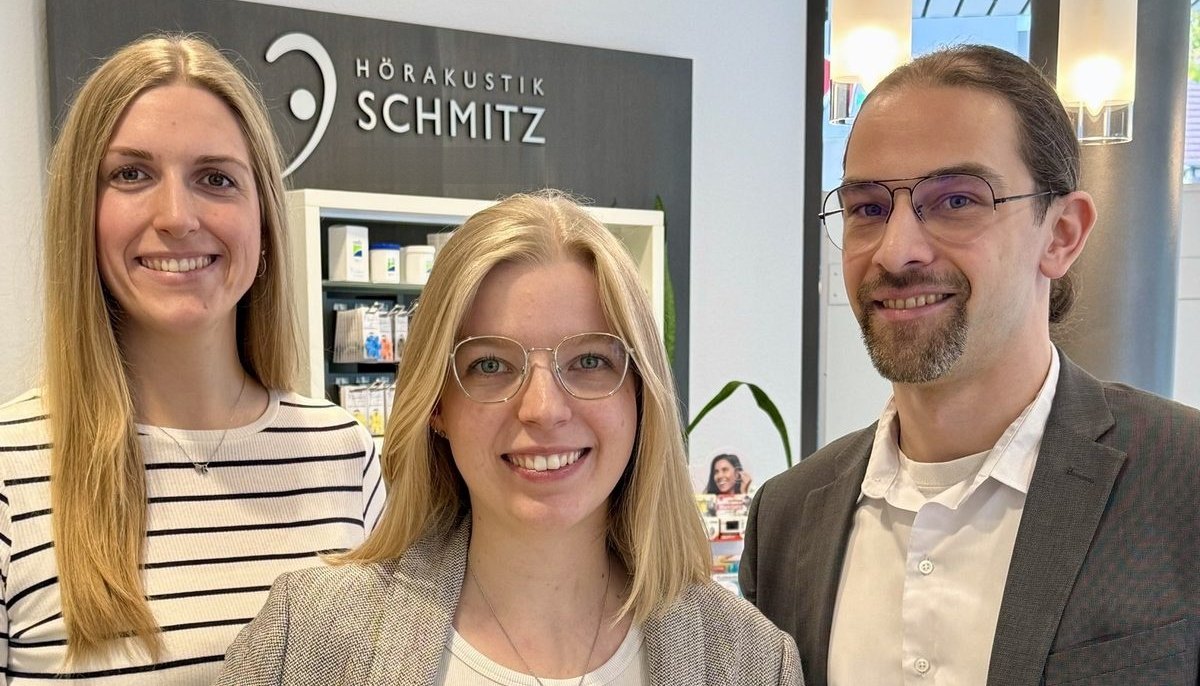 Drei Mitarbeitende von Hörakustik Schmitz im Fachgeschäft Lübbecke, lächelnd nebeneinander